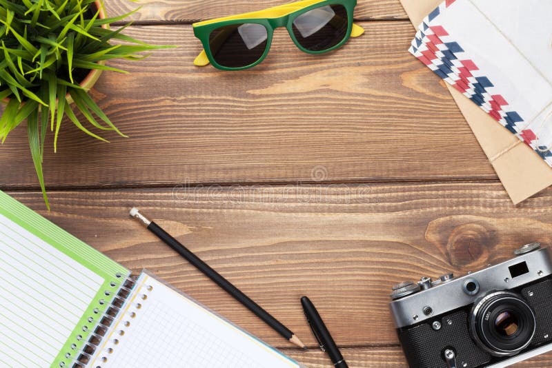 Appareil-photo, lunettes de soleil et approvisionnements sur le bureau images libres de droits Appareil-photo, lunettes de soleil et approvisionnements sur le bureau images libres de droits