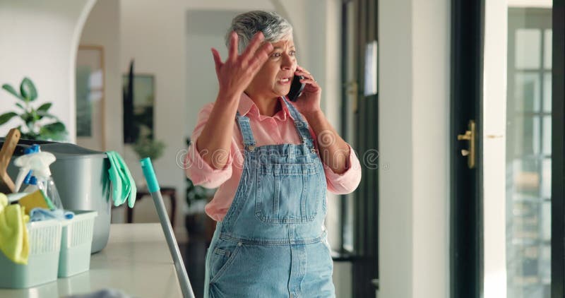 Appel téléphonique d'une femme mûre et maison avec nettoyage en colère et crier avec le conflit sur le réseau mobile. Smartphone e banque de vidéos
