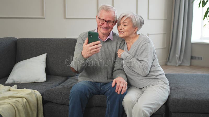 Appel vidéo. Joyeuse femme de couple avec smartphone avec appel vidéo. Mon vieux grand-père grand-mère qui parle clips vidéos