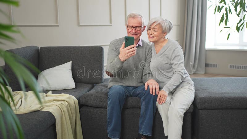 Appel vidéo. Joyeuse femme de couple avec smartphone avec appel vidéo. Mon vieux grand-père grand-mère qui parle clips vidéos