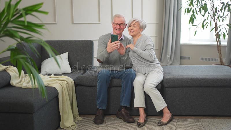 Appel vidéo. Joyeuse femme de couple avec smartphone avec appel vidéo. Mon vieux grand-père grand-mère qui parle clips vidéos