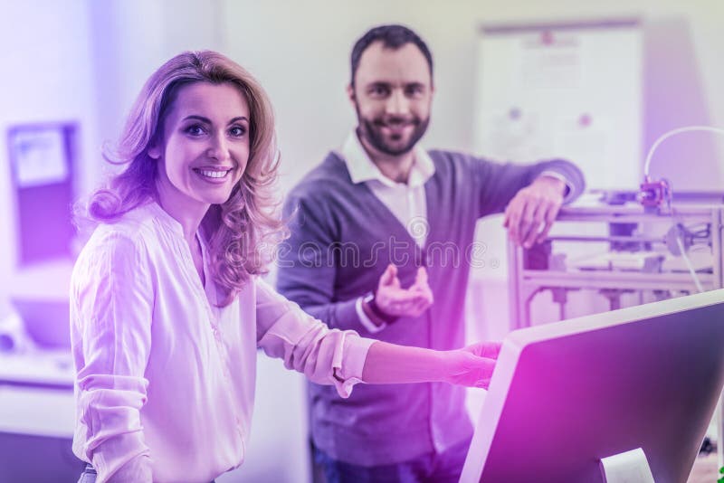 Appellieren der dunkeläugigen Frau, die beige Blusenstellung nahe ihrem Kollegen trägt lizenzfreie stockfotos Appellieren der dunkeläugigen Frau, die beige Blusenstellung nahe ihrem Kollegen trägt lizenzfreie stockfotos