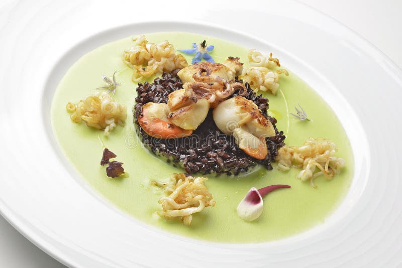 Appetizer Braised Scallops and Black Rice on Pea Cream Stock Photo