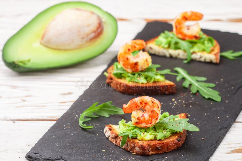 Appetizer of bread with seeds, shrimp, avocado and arugula. Crostini. Bruschetta. Sandwich. Antipasti. Selective focus royalty free stock photos Appetizer of bread with seeds, shrimp, avocado and arugula. Crostini. Bruschetta. Sandwich. Antipasti. Selective focus royalty free stock photos