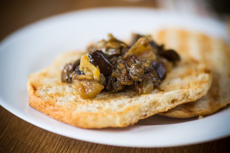 Appetizer of cooked eggplant with vegetables on bread