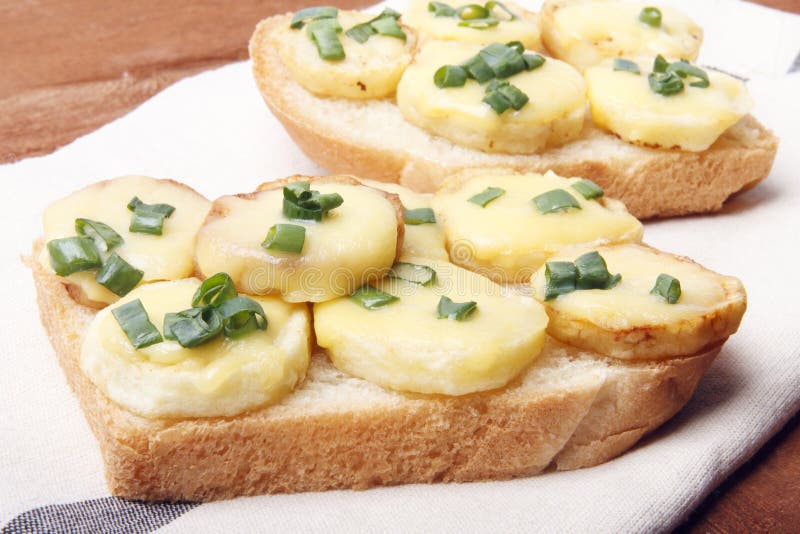 Appetizer of wheat bread, potatoes, cheese and green onions