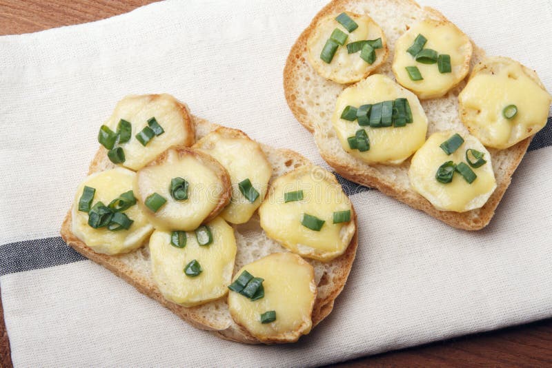 Appetizer of wheat bread, potatoes, cheese and green onions