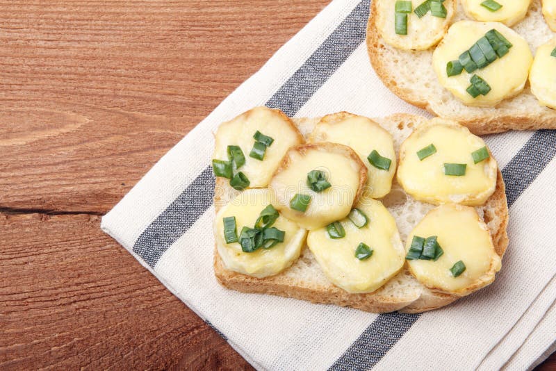 Appetizer of wheat bread, potatoes, cheese and green onions