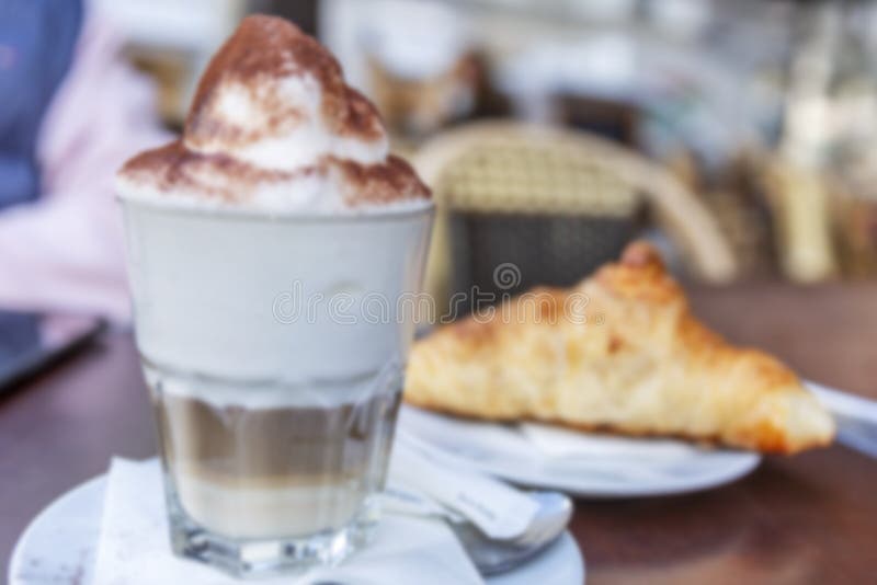 Appetizing cappuccino with croissant on a table in a cafe. Blurred. Background. Time for coffee royalty free stock image Appetizing cappuccino with croissant on a table in a cafe. Blurred. Background. Time for coffee royalty free stock image