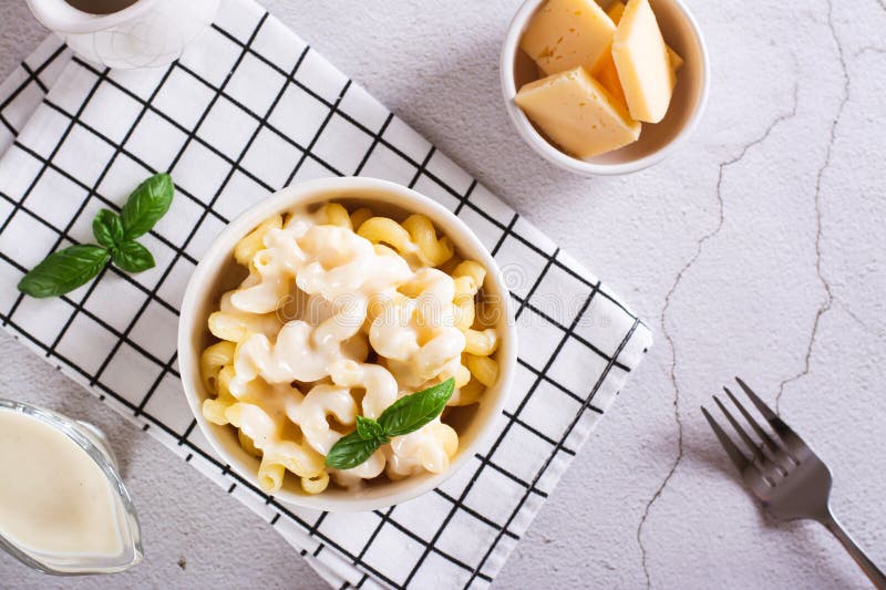 Appetizing pasta with cheese sauce and basil in a bowl on the table top view royalty free stock image