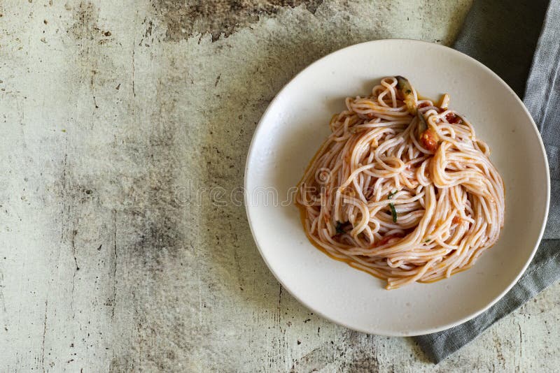 Appetizing pasta with tomatoes, fragrant Basil and eggplant on a beautiful plate on a gray background royalty free stock images