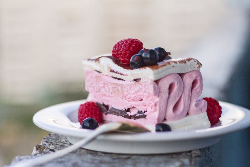 Appetizing pink and white ice cream with chocolate and berries of raspberries and black currant on a plate for dessert. royalty free stock image Appetizing pink and white ice cream with chocolate and berries of raspberries and black currant on a plate for dessert. royalty free stock image
