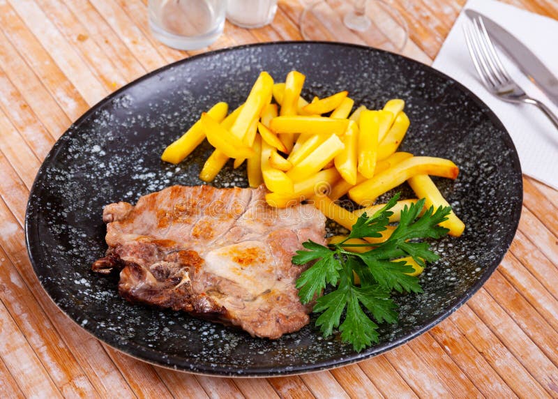 Roasted Bone-in Pork Chop with Crispy French Fries Stock Photo - Image