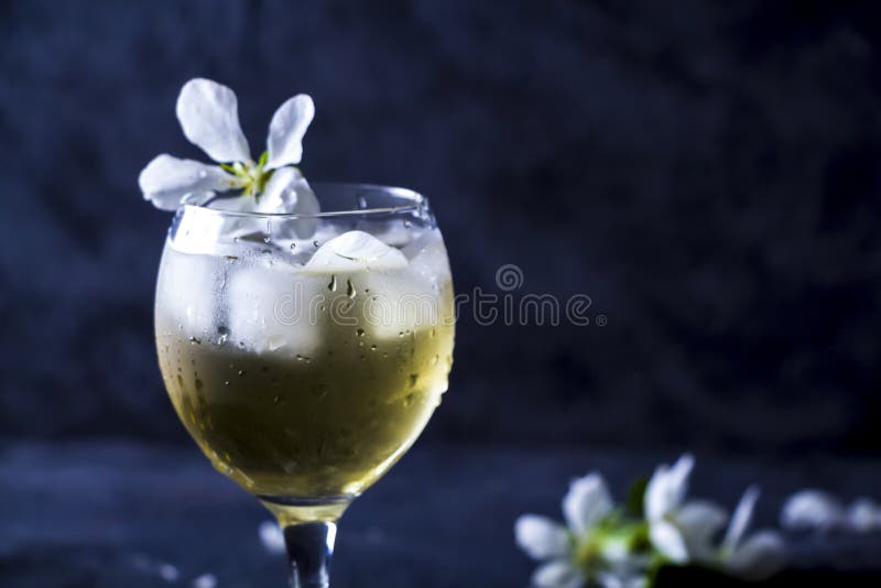 Apple alcoholic cocktail with sparkling wine in glass on a dark background. Refreshing cool summer drink, lemonade or ice tea