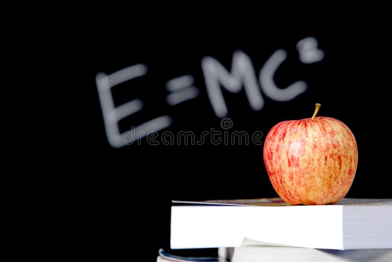 An apple on a stack of books on the teachers desk. An apple on a stack of books on the teachers desk