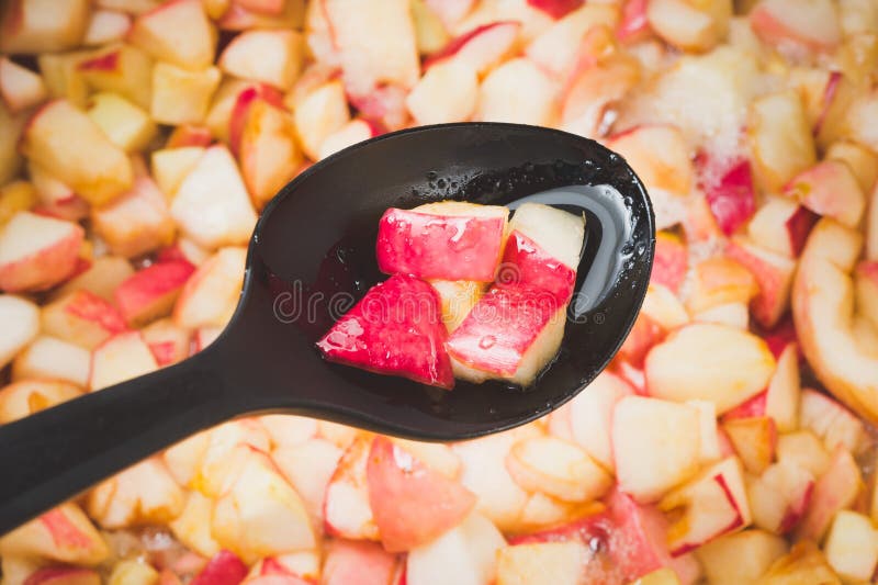Apple bloquent la fabrication dans le processus, foyer sur les morceaux de pomme mettant en forme de tasse u. Apple bloquent la fabrication dans le processus, foyer sur les morceaux de pomme mettant en forme de tasse dans la poche noire avec du jus de ébullition à l'arrière-plan