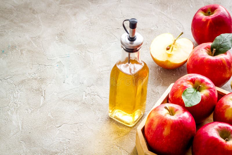 Apple Cider Vinegar in Glass Bottle with Fresh Red Apples Stock Photo