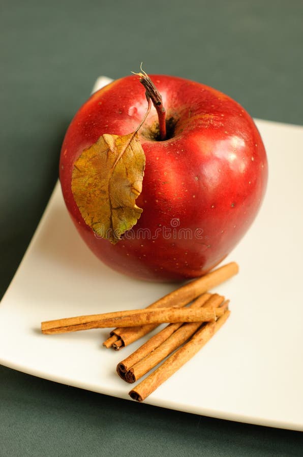 Apple with cinnamon and autumn leaves