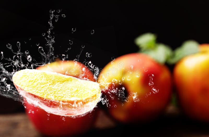 Apple con agua que salpica, fondo oscuro foto de archivo Apple con agua que salpica, fondo oscuro foto de archivo