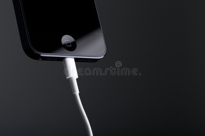 Apple iPhone 5 och Lightingkabel arkivbild Apple iPhone 5 och Lightingkabel arkivbild