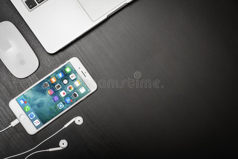 Apple iPhone 8 Plus met MacBook Pro op een zwart tafelblad stock foto's