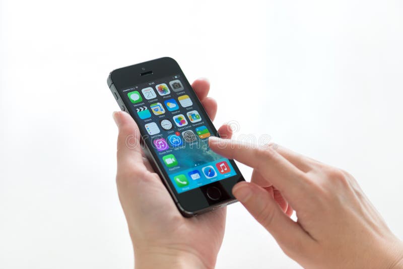 KIEV, UKRAINE - MAY 21, 2014: Person holding a brand new black Apple iPhone 5S, the most advanced smartphone in part of the iPhone line. Developed by Apple inc. and was released on September 20, 2013. KIEV, UKRAINE - MAY 21, 2014: Person holding a brand new black Apple iPhone 5S, the most advanced smartphone in part of the iPhone line. Developed by Apple inc. and was released on September 20, 2013.