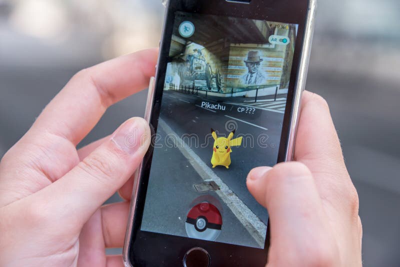 Apple iPhone5s with Pikachu from Pokemon Go application, hands of a teenager playing on the first day of the launching of the game in France. Apple iPhone5s with Pikachu from Pokemon Go application, hands of a teenager playing on the first day of the launching of the game in France