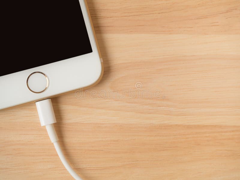 Apple iPhone6 som laddar med blixtUSB kabel royaltyfri fotografi Apple iPhone6 som laddar med blixtUSB kabel royaltyfri fotografi