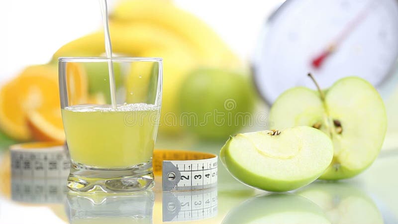 Apple juice poured in glass, fruit meter scales diet food