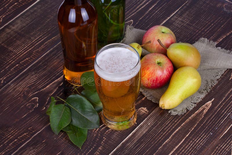Apple and pear cider glass and bottles with fruits.