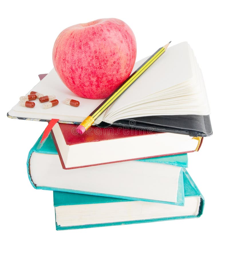 Apple and pills on big pile of books