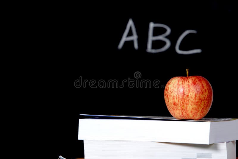 Apple on stack of books in classroom