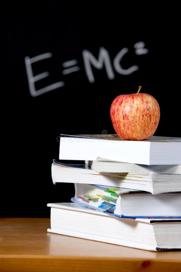 Apple on stack of books in classroom