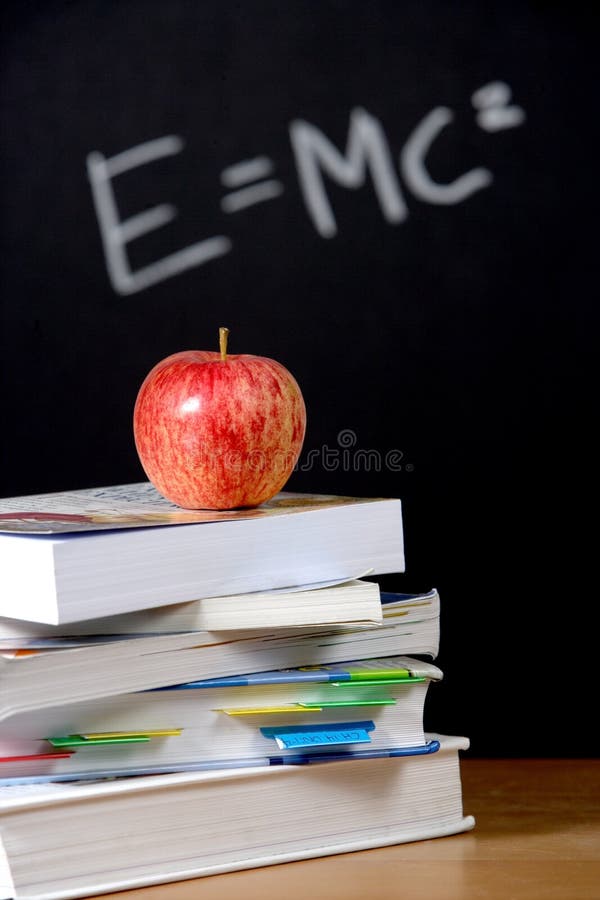 Apple on stack of books in classroom