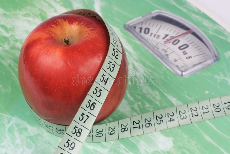 Apple, tape measure and scale