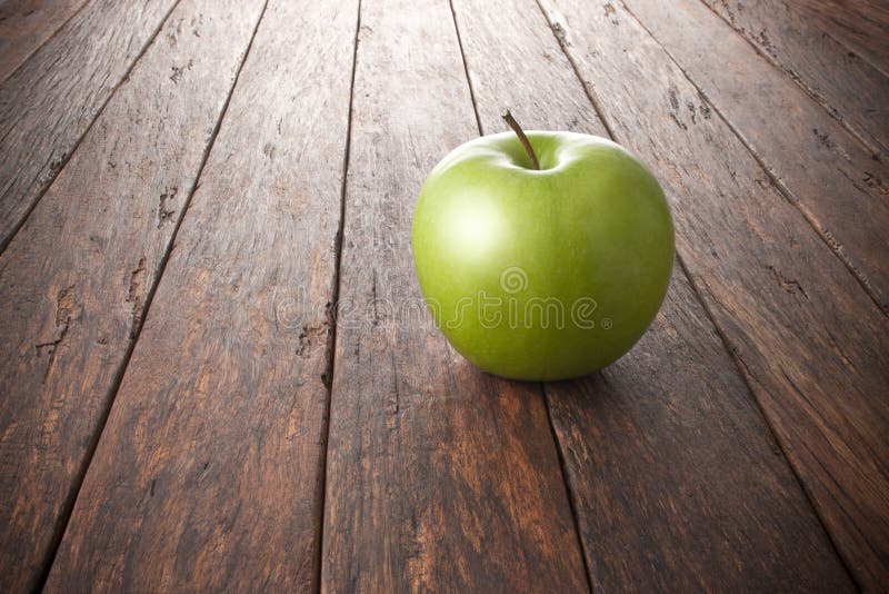 Jeden zelený jablko na vidiecky drevo.