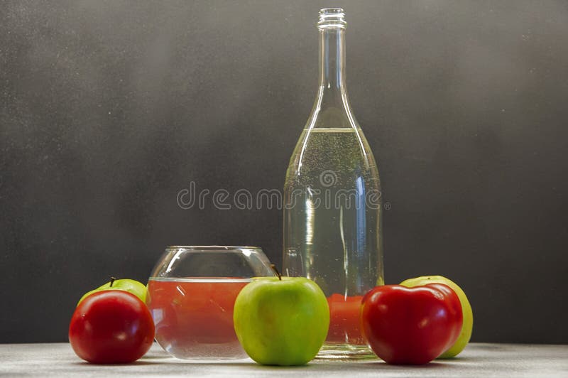 Photo apples green and red tomatoes with bottle and glass on mixed background royalty free stock images
