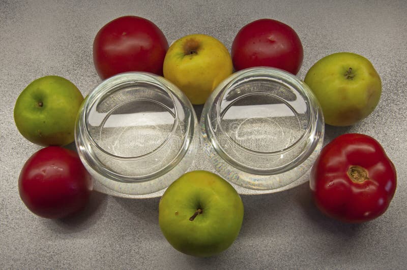 Photo apples green and red tomatoes with two glasses on gray background royalty free stock image