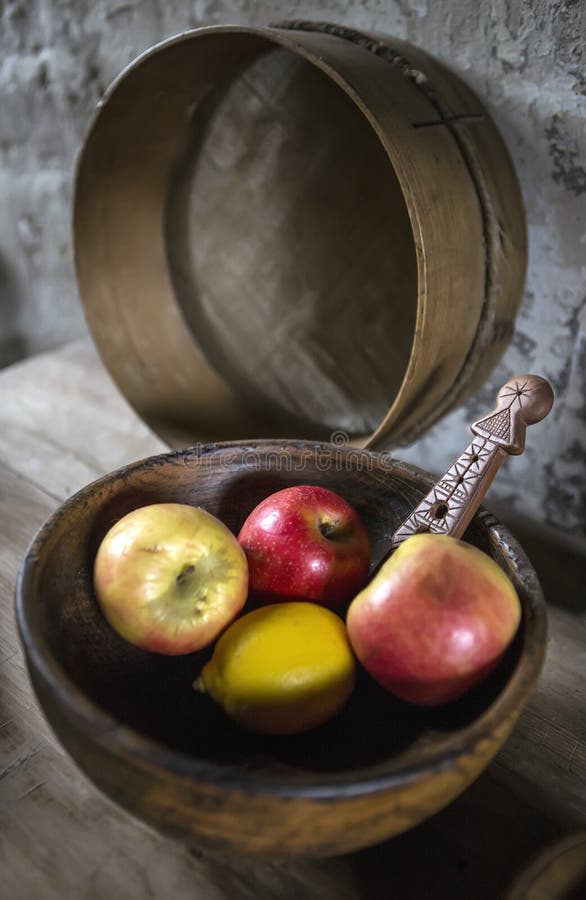 Apples and lemon in vintage wooden bowl still life