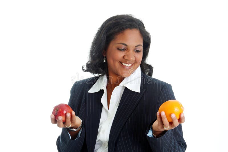 Woman comparing apples and oranges on a white background