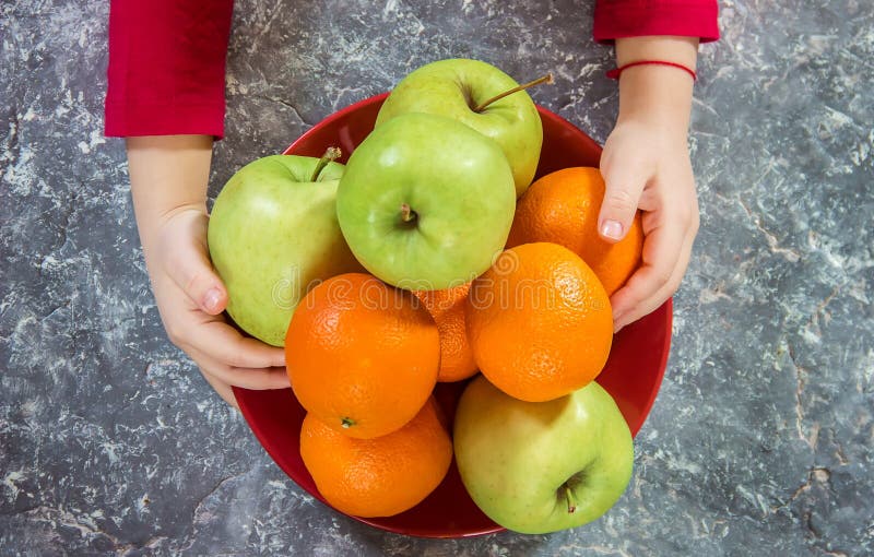 Apples and Oranges in the Hands of a Child. Stock Photo Image of love