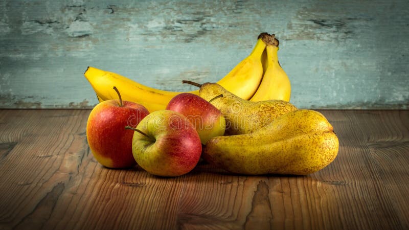 Apples, pears and bananas on a wooden table.