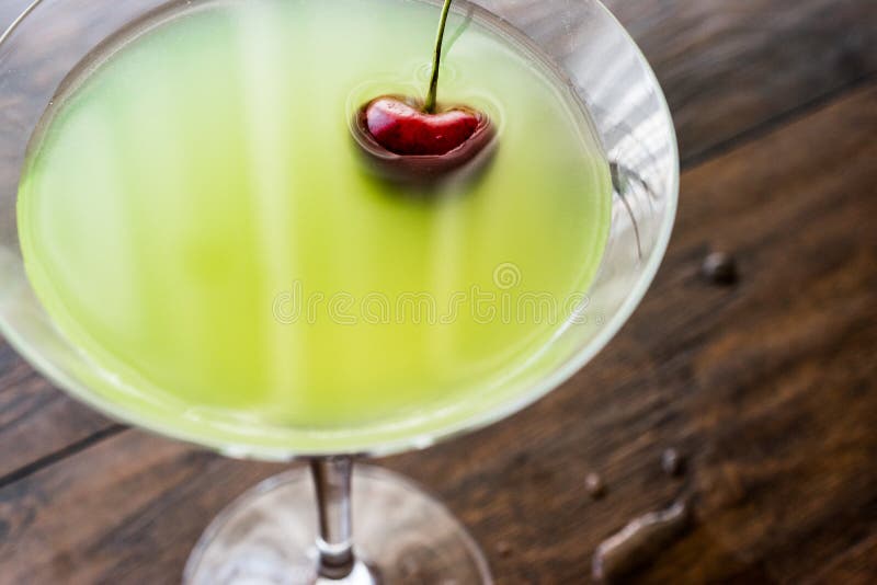 Appletini coctail med körsbäret på träyttersida arkivfoton Appletini coctail med körsbäret på träyttersida arkivfoton