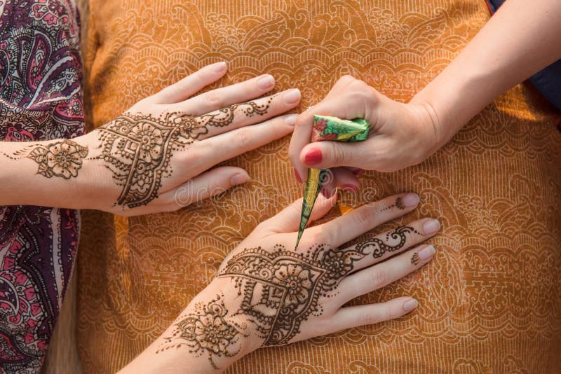 Applicazione del tatuaggio del hennè sulle mani delle donne