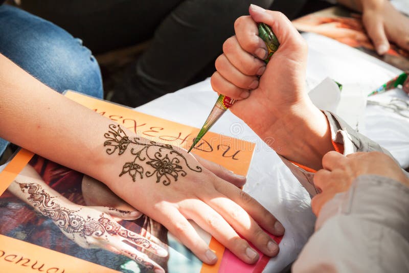 Applicazione della pasta o di mehndi del hennè sulla mano femminile fotografia stock libera da diritti Applicazione della pasta o di mehndi del hennè sulla mano femminile fotografia stock libera da diritti