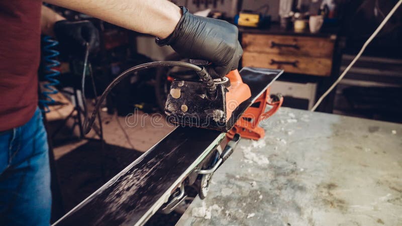 Applicazione di cera calda alla base da sci con ferro Applicazione Della Cera Di Ski Alla Base Di Ski Sintonizzazione base Barre fotografia stock libera da diritti Applicazione di cera calda alla base da sci con ferro Applicazione Della Cera Di Ski Alla Base Di Ski Sintonizzazione base Barre fotografia stock libera da diritti