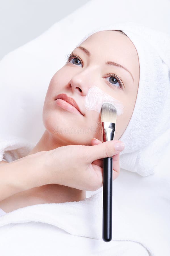 Applicera beauticiancosmeticmaskeringen arkivfoto