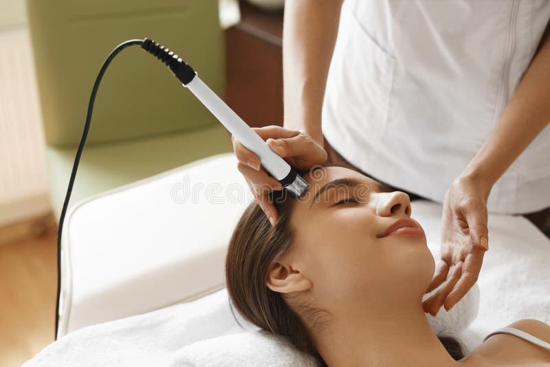 applicera genomskinlig fernissa för omsorgshud Kvinna som får ansikts- syre Jet Peeling Treatment arkivfoto applicera genomskinlig fernissa för omsorgshud Kvinna som får ansikts- syre Jet Peeling Treatment arkivfoto