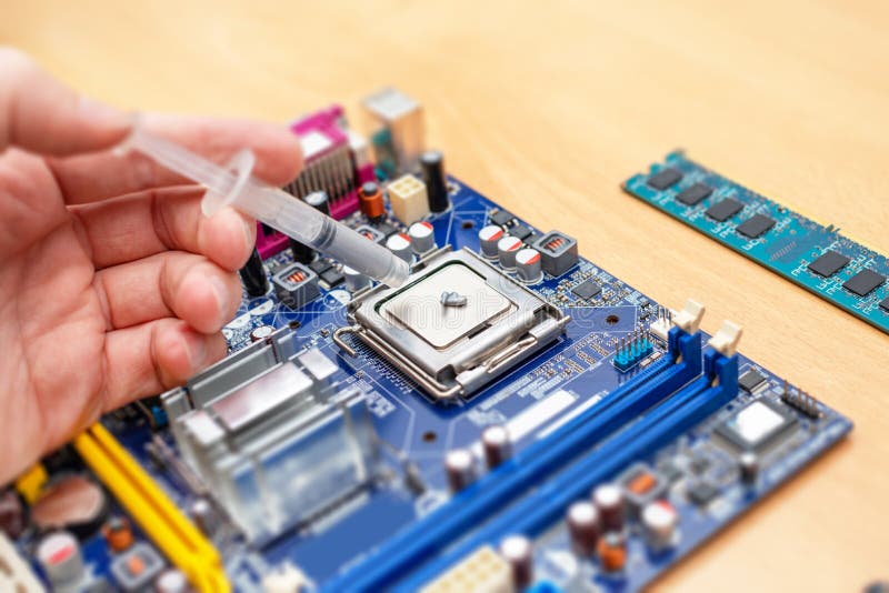 Applying thermal paste to a computer processor. Processor installation concept and cooling solution stock photography