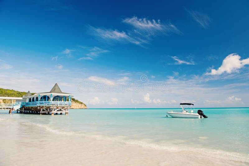 Appr?ciez les avantages ?tant pr?s de la mer Pavillon et bateau de l'eau de turquoise de mer pr?s de plage Plage de sable de mer photos libres de droits Appr?ciez les avantages ?tant pr?s de la mer Pavillon et bateau de l'eau de turquoise de mer pr?s de plage Plage de sable de mer photos libres de droits